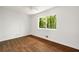 Empty bedroom with hardwood floors, white walls, and a window overlooking the greenery at 239 Devonwood Dr, Atlanta, GA 30328