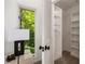 Open closet with wooden shelves and rods, located next to a window with leafy views at 239 Devonwood Dr, Atlanta, GA 30328