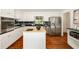 Spacious kitchen with stainless steel appliances, island, white cabinetry, and wood floors at 239 Devonwood Dr, Atlanta, GA 30328