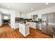 Bright kitchen features stainless steel appliances, island, white cabinets, and wood flooring at 239 Devonwood Dr, Atlanta, GA 30328