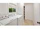 Clean laundry room featuring a washer, dryer, tiled floor, window, and extra storage shelves at 239 Devonwood Dr, Atlanta, GA 30328