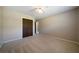 Carpeted bedroom featuring beige walls, a ceiling fan, and double wooden closet doors, ensuring comfort and style at 2921 Huntcliff Dr, Marietta, GA 30066