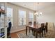 Well-lit dining room with wood floors, a decorative rug, and a classic chandelier at 3229 Hallmark Ln, Buford, GA 30519
