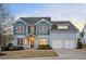 Beautiful two-story home featuring a well-maintained lawn, two-car garage, and inviting front entrance with lighting at 520 Tackett Farms Rd, Smyrna, GA 30082