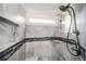 Modern tiled shower with glass door features a mosaic accent band and rain shower head at 520 Tackett Farms Rd, Smyrna, GA 30082