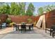Back patio featuring an outdoor dining area, comfortable seating, and a privacy fence with trees and shrubbery at 1906 Variations Ne Dr, Atlanta, GA 30329
