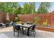 Back patio with outdoor dining, comfortable seating, shade umbrella, and lush landscaping for relaxation and entertaining at 1906 Variations Ne Dr, Atlanta, GA 30329