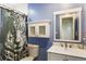 Bathroom featuring blue walls, a decorative mirror, and a shower with a cheetah-print curtain at 338 Patricia Sw Ave, Marietta, GA 30060
