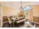 Well-lit dining room with tufted dining seating and elegant chandelier under an arched window at 7450 Chads Cir, Jonesboro, GA 30236