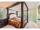 Elegant bedroom with a four-poster bed, neutral walls, and bright natural light from the windows at 7450 Chads Cir, Jonesboro, GA 30236