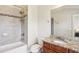 Well-lit bathroom featuring a bathtub with shower and a vanity with granite countertop at 3065 Arbor Song Ct, Cumming, GA 30041