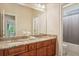 Elegant bathroom featuring double sinks with granite countertops and cherry wood cabinets at 3065 Arbor Song Ct, Cumming, GA 30041