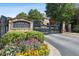 Arbor Chase community entrance with stone signage, colorful flowerbeds, and a security gate for privacy at 3065 Arbor Song Ct, Cumming, GA 30041