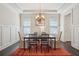 Traditional dining room featuring wainscoting, chandelier lighting, and a dark table with seating for six at 3065 Arbor Song Ct, Cumming, GA 30041