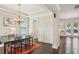 Elegant dining room with stylish lighting, dark wood floors, wainscoting, and views to bright back room at 3065 Arbor Song Ct, Cumming, GA 30041