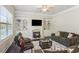 Comfortable living room with a fireplace, built-in shelving, and a large window offering outdoor views at 3065 Arbor Song Ct, Cumming, GA 30041