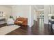 Open concept living area with hardwood floors, piano, white chairs and views to hallway and the kitchen at 3065 Arbor Song Ct, Cumming, GA 30041
