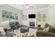 Cozy living room with fireplace, built-in shelving, and a large window providing natural light at 3065 Arbor Song Ct, Cumming, GA 30041
