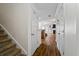 Hallway with hardwood floors that lead to a staircase and living area, creating a seamless flow at 5570 Stonewood Ct, Norcross, GA 30093