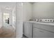 Neat laundry area with white appliances, complementing the neutral walls and flooring at 5570 Stonewood Ct, Norcross, GA 30093