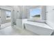 Bright bathroom featuring modern tub, glass shower, and large windows overlooking outdoor landscape at 175 Paislee Park (Lot # 11 Paislee Park) Dr, Fayetteville, GA 30215