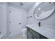 Well lit bathroom with white subway tiles and a white marbled-tile floor and a large round mirror at 175 Paislee Park (Lot # 11 Paislee Park) Dr, Fayetteville, GA 30215