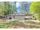 A grassy backyard with a carport, patio, and chain-link fence at 190 Sunrise Cir, Riverdale, GA 30274
