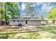 A grassy backyard with a carport, patio, chain-link fence, and an area for gardening at 190 Sunrise Cir, Riverdale, GA 30274