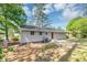 A grassy backyard with a carport, patio, chain-link fence, and an area for gardening at 190 Sunrise Cir, Riverdale, GA 30274