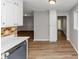 Open-concept kitchen with white cabinets, stainless steel appliances, and modern wood-look flooring at 190 Sunrise Cir, Riverdale, GA 30274