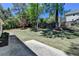 A spacious backyard with a well-maintained lawn, mature trees, and a concrete patio is perfect for outdoor activities at 5567 Stapleton Dr, Dunwoody, GA 30338