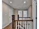 Upstairs hallway features wood floors, white doors, and a wooden and white banister at 5567 Stapleton Dr, Dunwoody, GA 30338