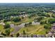 Overhead shot showing homes bordering golf course and small pond surrounded by lush forest at 177 Grandmar Chase, Canton, GA 30115