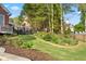Landscaped backyard with retaining wall and lush lawn, enclosed by a black wrought iron fence at 177 Grandmar Chase, Canton, GA 30115