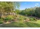 Expansive backyard featuring lush landscaping, a manicured lawn, and a secure wrought iron fence at 177 Grandmar Chase, Canton, GA 30115