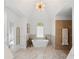 Bright bathroom featuring vaulted ceiling, free standing tub, large window, and a separate shower area at 177 Grandmar Chase, Canton, GA 30115