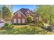 Beautiful two-story brick home featuring a manicured lawn and lush landscaping at 177 Grandmar Chase, Canton, GA 30115
