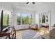 Bright sun room with large windows offering nature views, hardwood floors, and a comfortable seating area at 177 Grandmar Chase, Canton, GA 30115