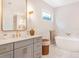 Elegant bathroom with gray cabinets, gold fixtures, marble walls, and a soaking tub at 1862 Lake Ebenezer Trl, Marietta, GA 30066