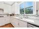 Close-up of the kitchen with white cabinetry, sleek countertops, tile backsplash, and a view to the backyard at 1862 Lake Ebenezer Trl, Marietta, GA 30066