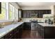 Well-lit kitchen with dark cabinets, stone countertops, and stainless steel appliances at 2813 White Oak Ln, Decatur, GA 30032