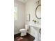 Bright powder room featuring a pedestal sink, round mirror, and modern finishes at 2813 White Oak Ln, Decatur, GA 30032