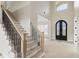 Bright foyer featuring a staircase with wooden steps and wrought iron railing and a double front door at 5694 Brendlynn Dr, Suwanee, GA 30024