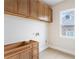 Unfinished laundry room, showcasing cabinets and natural light from the large window at 5694 Brendlynn Dr, Suwanee, GA 30024