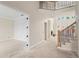 Spacious living area featuring white walls, wood trim and staircase with wrought iron railing at 5694 Brendlynn Dr, Suwanee, GA 30024