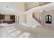Expansive living room featuring a soaring ceiling, staircase, and an arched front doorway at 5694 Brendlynn Dr, Suwanee, GA 30024