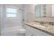 Bathroom featuring a granite countertop, white cabinets, bathtub, and window at 2041 W Flat Shoals Ter, Decatur, GA 30034