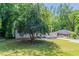 Cozy single-story home with a front porch, a well-manicured lawn, and lush green trees in the background at 2041 W Flat Shoals Ter, Decatur, GA 30034