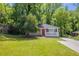Charming brick bungalow with a red door, front porch, and a well-maintained lawn surrounded by mature trees at 2041 W Flat Shoals Ter, Decatur, GA 30034
