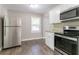 Bright eat-in kitchen with stainless steel appliances, white cabinets, granite countertops, and wood-look flooring at 2041 W Flat Shoals Ter, Decatur, GA 30034